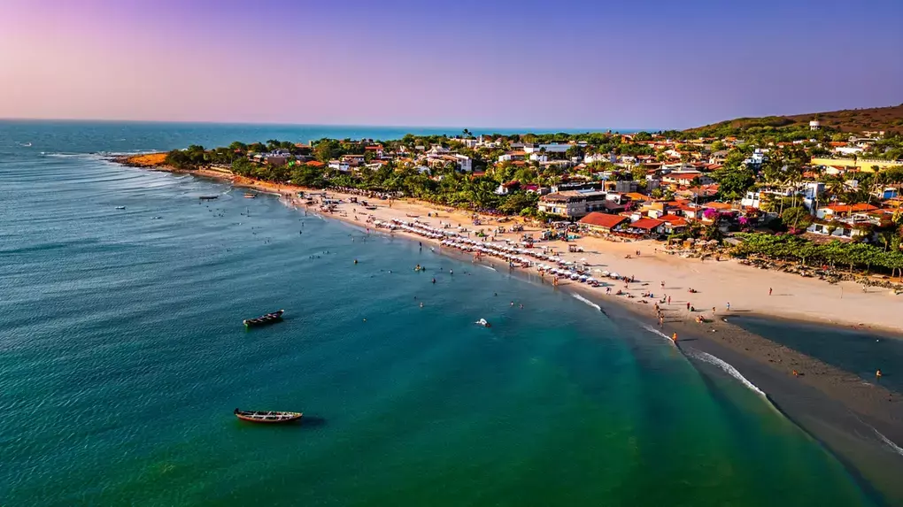 Vista aérea de Jericoacoara mostrando a vila entre dunas de areia e o oceano azul turquesa Vista aérea de Jericoacoara mostrando a vila entre dunas de areia e o oceano azul turquesa
